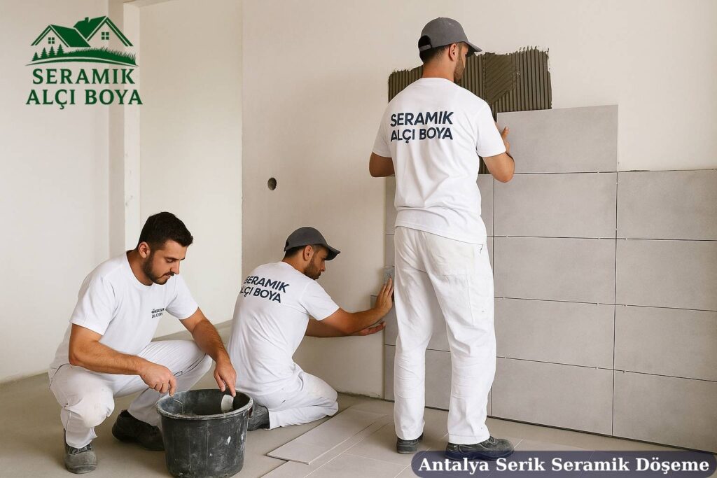 Antalya Serik Seramik Döşeme 2025 3 Antalya Serik Seramik Döşeme Serik’te bir evin banyo duvarına seramik döşemesi yapan iki usta, Seramik Alçı Boya logolu iş kıyafetleriyle titizlikle çalışma yapıyor.